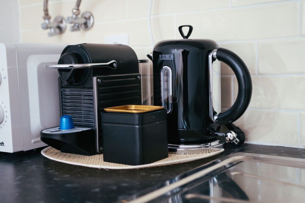 oil-1 Sleek black coffee maker and kettle on a modern kitchen countertop, ideal for brewing.